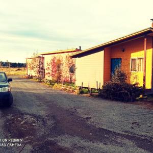 een auto geparkeerd aan de kant van een weg naast een gebouw bij Cabañas Juan José in Castro
