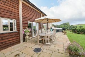 a patio with a table and an umbrella at Lake View in Crediton