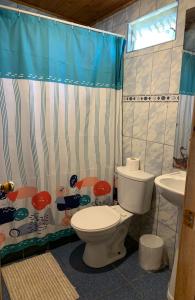 a bathroom with a toilet and a shower curtain at Lefun & Lafquen de Pichilemu in Pichilemu