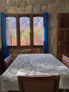 une salle à manger avec une table et une grande fenêtre dans l'établissement Hospedaje Fortaleza Indigena, à Tilcara