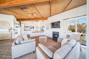un soggiorno con due divani e un camino di Salt Bush Beach House~the ultimate Fleurieu escape a Aldinga Beach