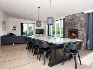 a dining room with a table and chairs and a fireplace at Holiday home Glesborg L in Glesborg