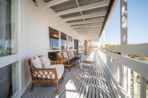 un portico di una casa con sedie e finestre di Salt Bush Beach House~the ultimate Fleurieu escape a Aldinga Beach