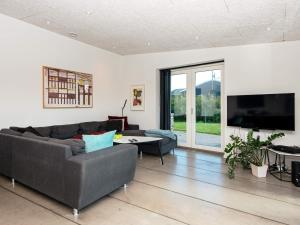 a living room with a couch and a tv at Holiday home Glesborg L in Glesborg