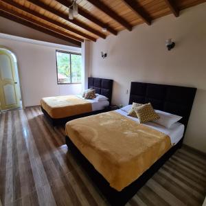 a bedroom with two beds and a window at Hotel Casa Confort in Santa Rosa de Cabal