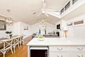 een keuken en een woonkamer met een plafondventilator bij The Hamptons Beach House near Dutchie's walk to Nelson Bay in Nelson Bay