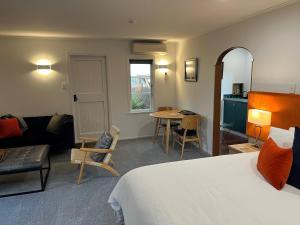 a hotel room with a bed and a living room at Shy Cottage and Studio in Greytown