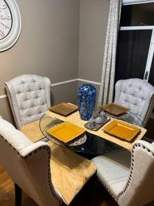 a dining room table with chairs and a blue vase on it at Manuel Y Sonia-La casa de los Angeles in Long Beach