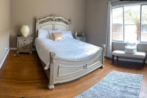 a bedroom with a large bed and a chair at Manuel Y Sonia-La casa de los Angeles in Long Beach