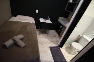 a small bathroom with a toilet and a sink at Hotel Com.Viver in Campinas