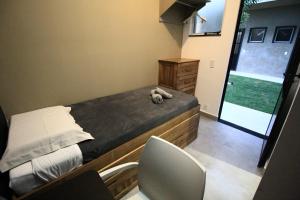 Hotel Com.Viver في كامبيناس: غرفة نوم صغيرة مع سرير مع دمية دب عليها