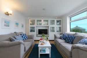a living room with two couches and a tv at Atlantic Waves in Carbis Bay