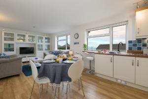 a kitchen and living room with a table and chairs at Atlantic Waves in Carbis Bay