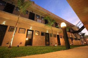 a building with palm trees in front of it at Hotel Com.Viver in Campinas