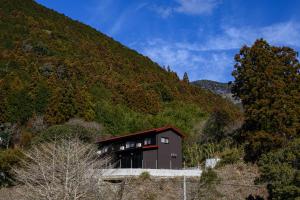 une maison sur le flanc d'une montagne dans l'établissement 日本の秘境で味わう絶品地鶏 ジローのおうち, à Aki