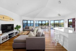 una gran sala de estar con una tabla de surf en la pared en Wanda Point House - pure tranquillity and walk to beach, en Salamander Bay