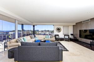 a living room with a couch and a tv at Penthouse Palace - Luxurious Harbourview Location in Nelson Bay