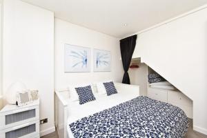 a white bedroom with a bed and a staircase at Penthouse Palace - Luxurious Harbourview Location in Nelson Bay