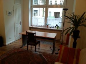 ein Wohnzimmer mit einem Tisch und einem Fenster in der Unterkunft Apartment Stadtoase Wilmersdorf in Berlin