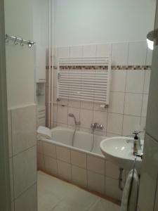 ein Badezimmer mit einer Badewanne und einem Waschbecken in der Unterkunft Apartment Stadtoase Wilmersdorf in Berlin