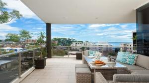 a balcony with a table and a view of the city at Harbour View Penthouse - The Perfect Location in Nelson Bay