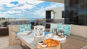 a table on a balcony with food on it at Harbour View Penthouse - The Perfect Location in Nelson Bay