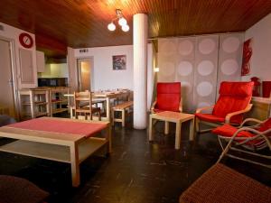 a dining room with red chairs and a table at Appartement Chamrousse, 3 pièces, 8 personnes - FR-1-549-108 in Chamrousse