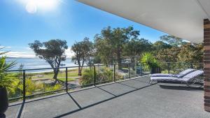 a balcony with a bench and a view of the ocean at Dutchie's Dream - Glorious Views And Opposite Dutchies Beach in Nelson Bay