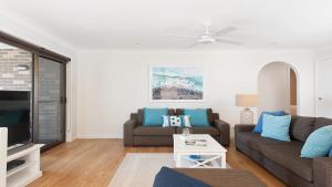 sala de estar con sofá y TV en Dutchie's Dream - Glorious Views And Opposite Dutchies Beach, en Nelson Bay