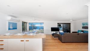 cocina y sala de estar con sofá y mesa en Dutchie's Dream - Glorious Views And Opposite Dutchies Beach, en Nelson Bay