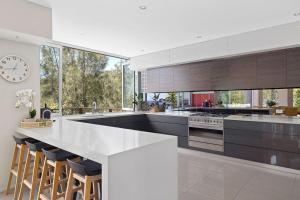 a kitchen with a large counter and a clock on the wall at Grandview - Luxurious Entertainer with Spectacular Views in Nelson Bay