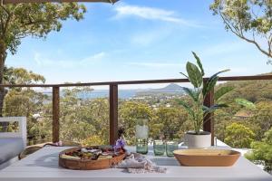 a table with a bowl of food on top of a balcony at Grandview - Luxurious Entertainer with Spectacular Views in Nelson Bay
