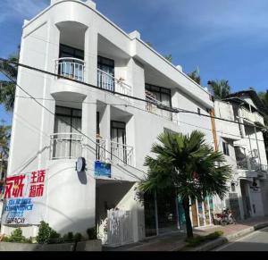 a white building with a palm tree in front of it at MY STATION HOTEL in Boracay