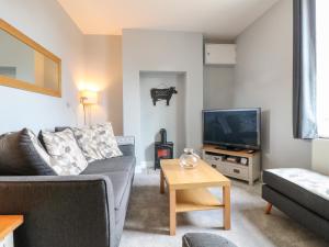 ein Wohnzimmer mit einem Sofa und einem TV in der Unterkunft Meadow View in Ashbourne