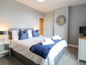 ein Schlafzimmer mit einem großen Bett mit blauen Kissen in der Unterkunft Meadow View in Ashbourne