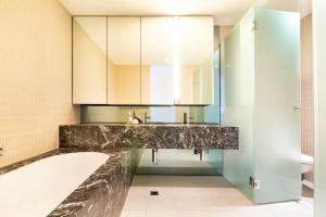 a bathroom with a sink and a bath tub at Luxury beachside apartment in Melbourne