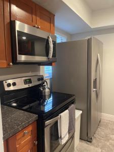 a kitchen with a stove and a stainless steel refrigerator at Adorable Suite in Tampa. in Tampa