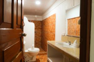 a bathroom with a toilet and a sink at Hotel Hoja de Oro Corcovado in Puerto Jiménez +54 photos