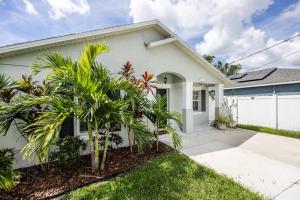 a white house with palm trees in front of it at Modern Luxury Home Located in Tampa! in Tampa