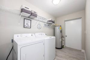 a laundry room with a washer and a refrigerator at Modern Luxury Home Located in Tampa! in Tampa