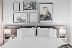 a bedroom with a white bed with four pictures on the wall at Pretty Rola 304 Luxury Apt w King Bed Central Area in Fort Lauderdale
