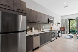 uma cozinha com um frigorífico de aço inoxidável e uma mesa em Pretty Rola 303 Signature Apartment w King Bed Brand new and Central Location em Fort Lauderdale