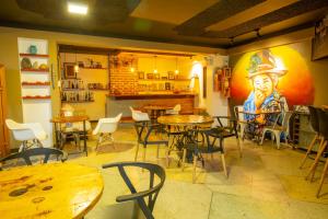 a restaurant with tables and chairs and a painting of a cowboy at Sosa House Eco Hotel Boutique in Huaraz