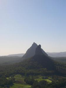
a mountain range with a mountain range behind it at Glass House Mountains Ecolodge in Glass House Mountains
