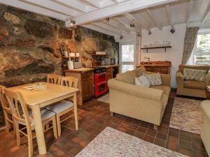 a kitchen and living room with a table and chairs at Bryn Afon in Caernarfon