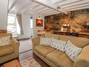 a living room with two couches and a stone wall at Bryn Afon in Caernarfon