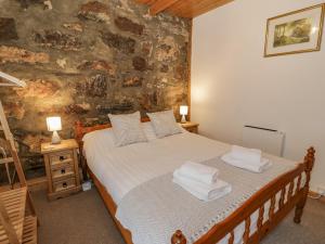 a bedroom with a bed with towels on it at Bryn Afon in Caernarfon