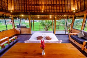 a room with a bed and a table and chairs at Canggu Wooden Green Paradise in Canggu