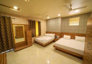 a bedroom with two beds and a mirror at Hotel Sundaram 5 Minutes Distance from Dargah in Ajmer