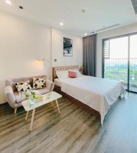 ein Schlafzimmer mit einem Bett, einem Sofa und einem Tisch in der Unterkunft Apartment 1BR-FL12th-R103 Building-Vinhome Ocean Park in Hanoi